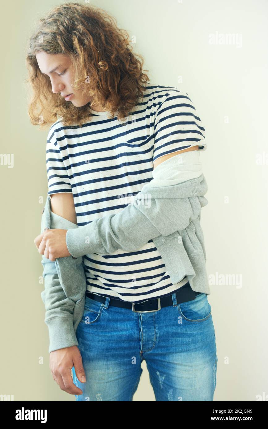 Tailoring his own style. Casual young man with long, curly hair. Stock Photo