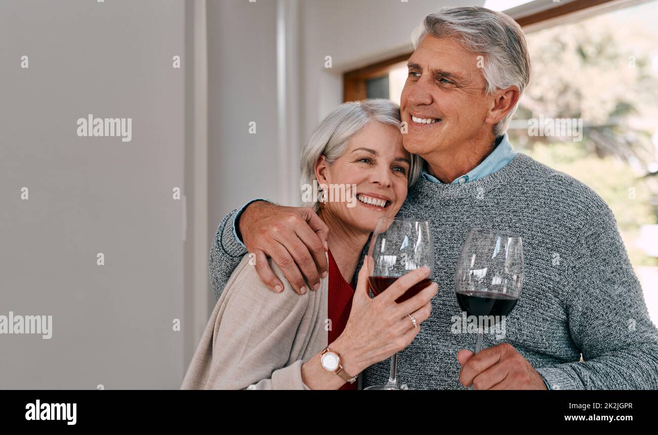 Nothing says romance like sharing some red wine. Shot of a happy mature couple having red wine together during a relaxing day at home. Stock Photo