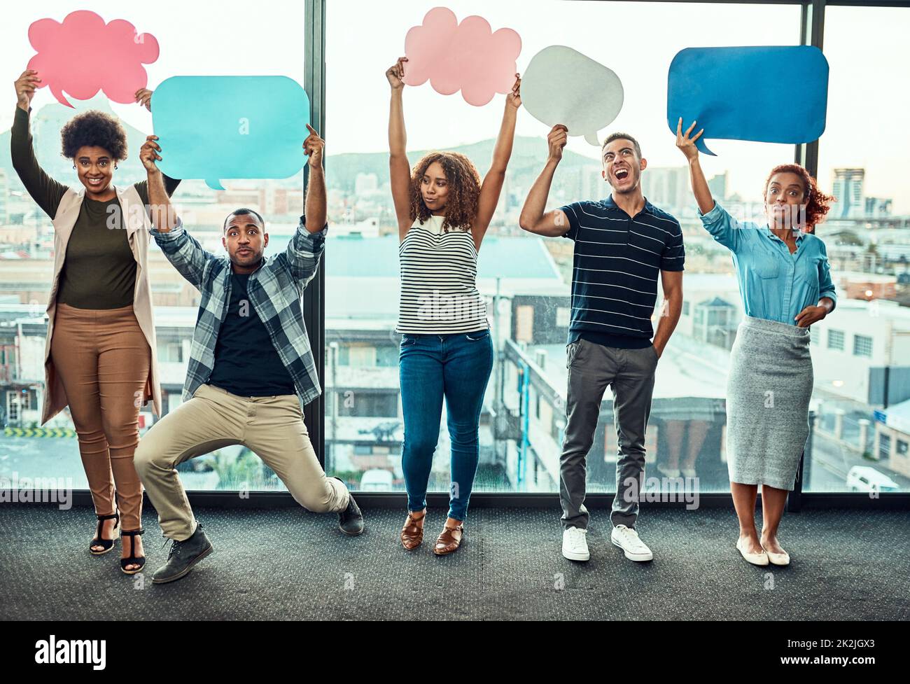 Hold your sign up high. Portrait of a cheerful young group of work ...