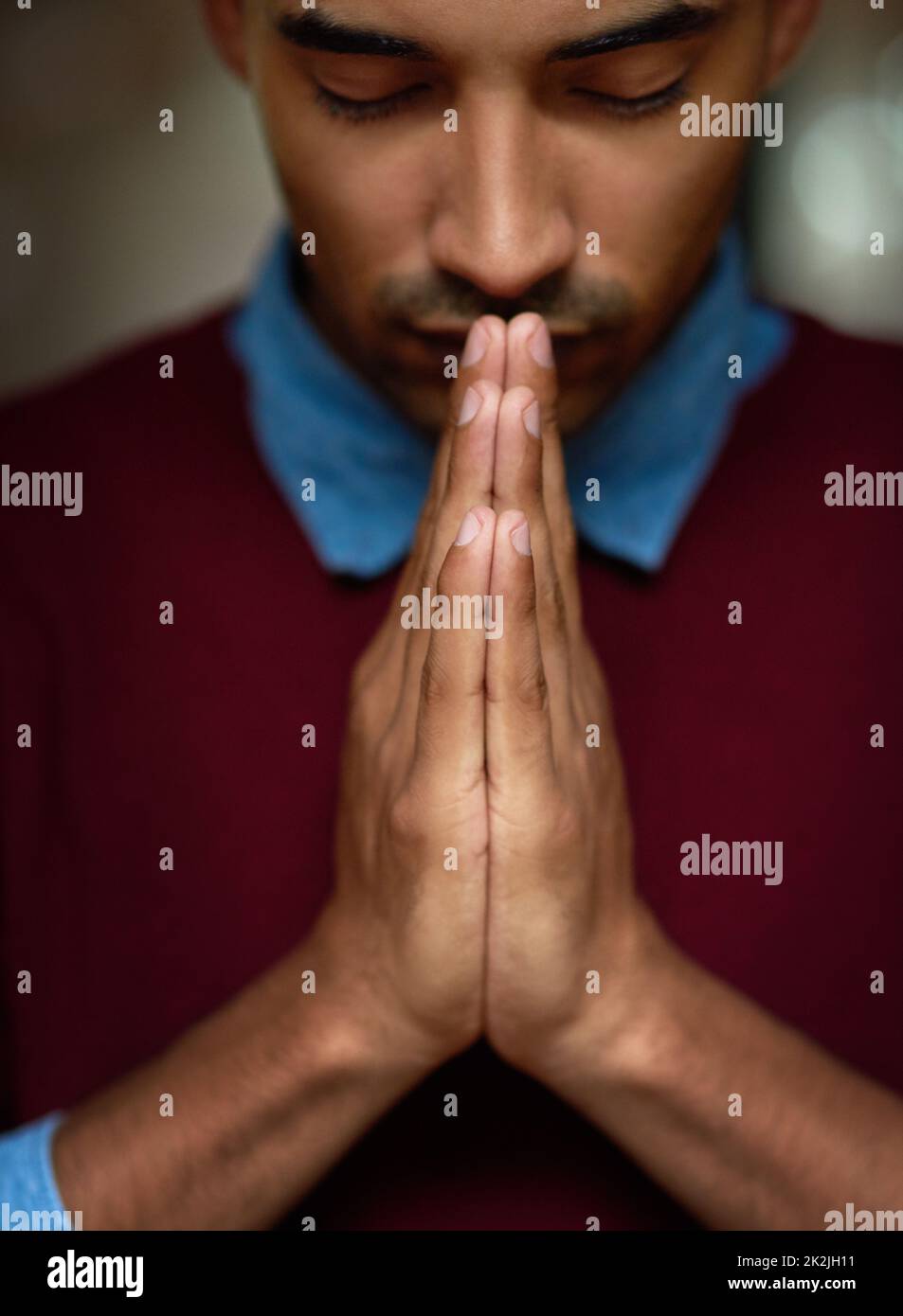 Theres only one place to turn to. Cropped shot of a young man holding his hands together in prayer. Stock Photo