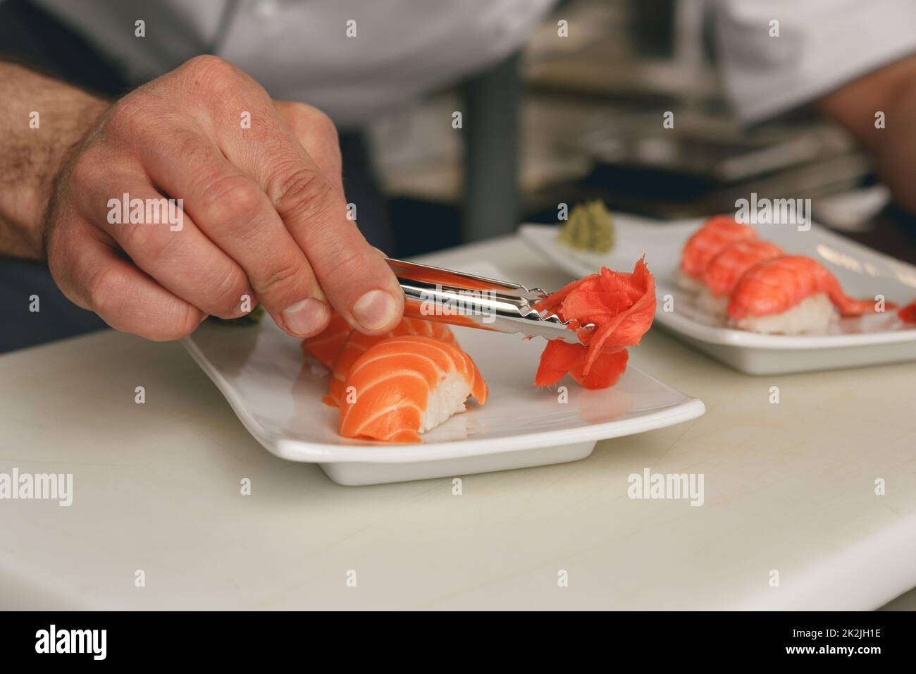 Close up of sushi master prepares sushi for serving in modern commercial kitchen Stock Photo