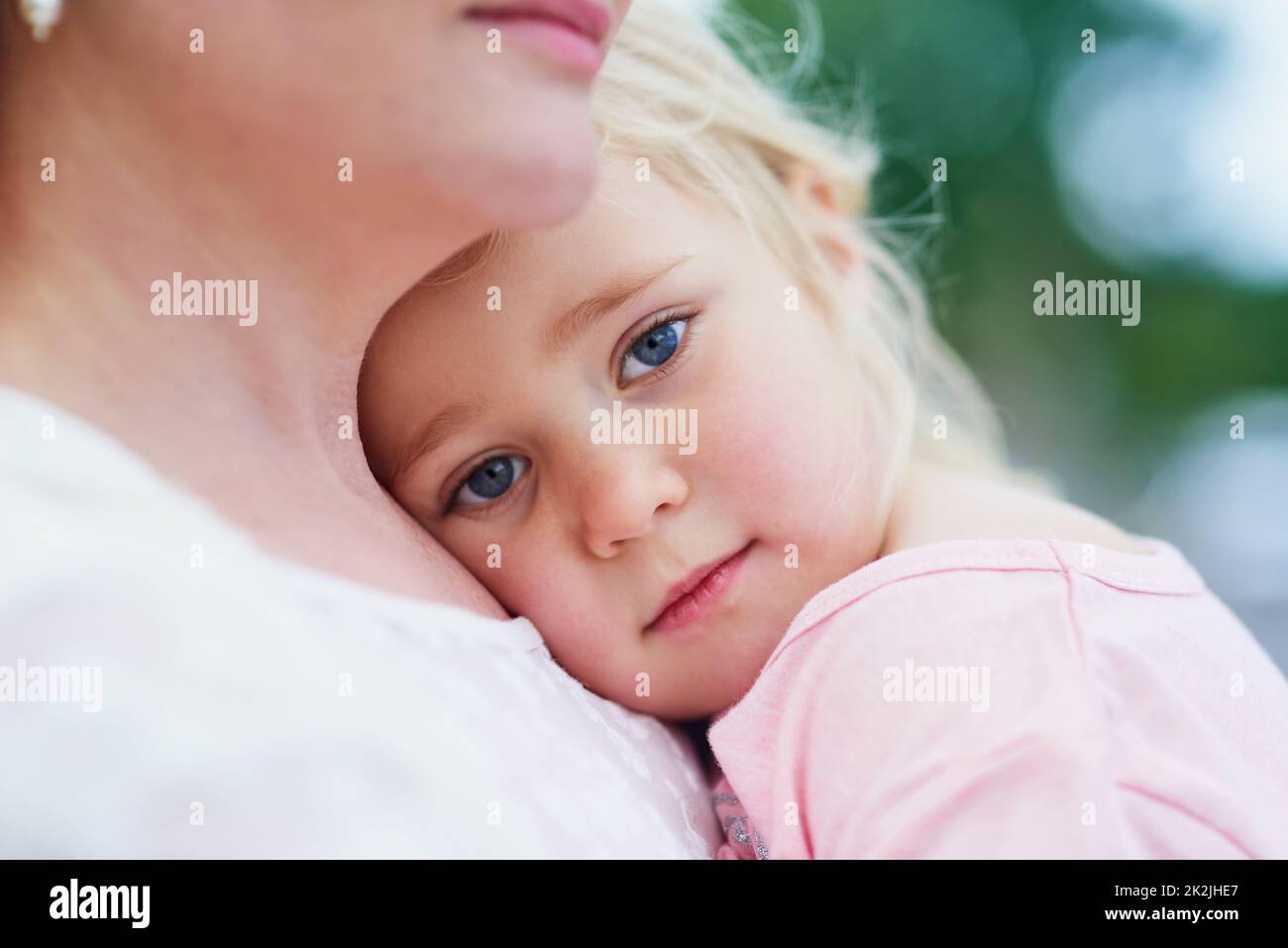 Im feeling blue.... Portait of a sad little girl being comforted by her mother outside. Stock Photo