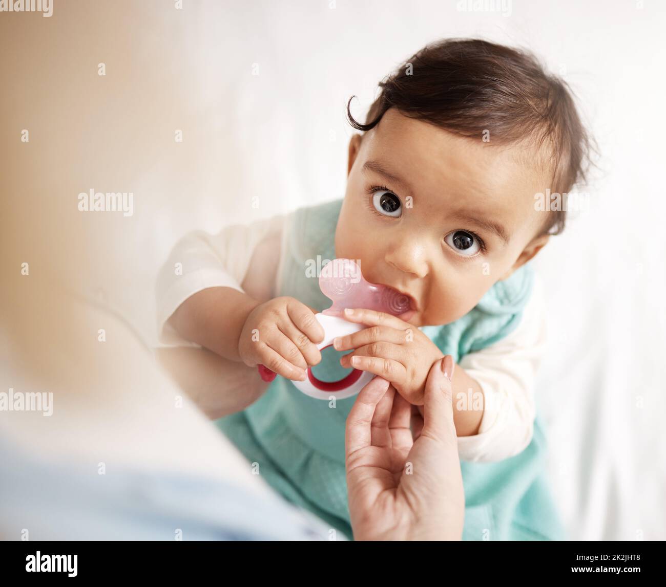 I hope this helps with the itching. Shot of an adorable little girl playing with a teething toy. Stock Photo