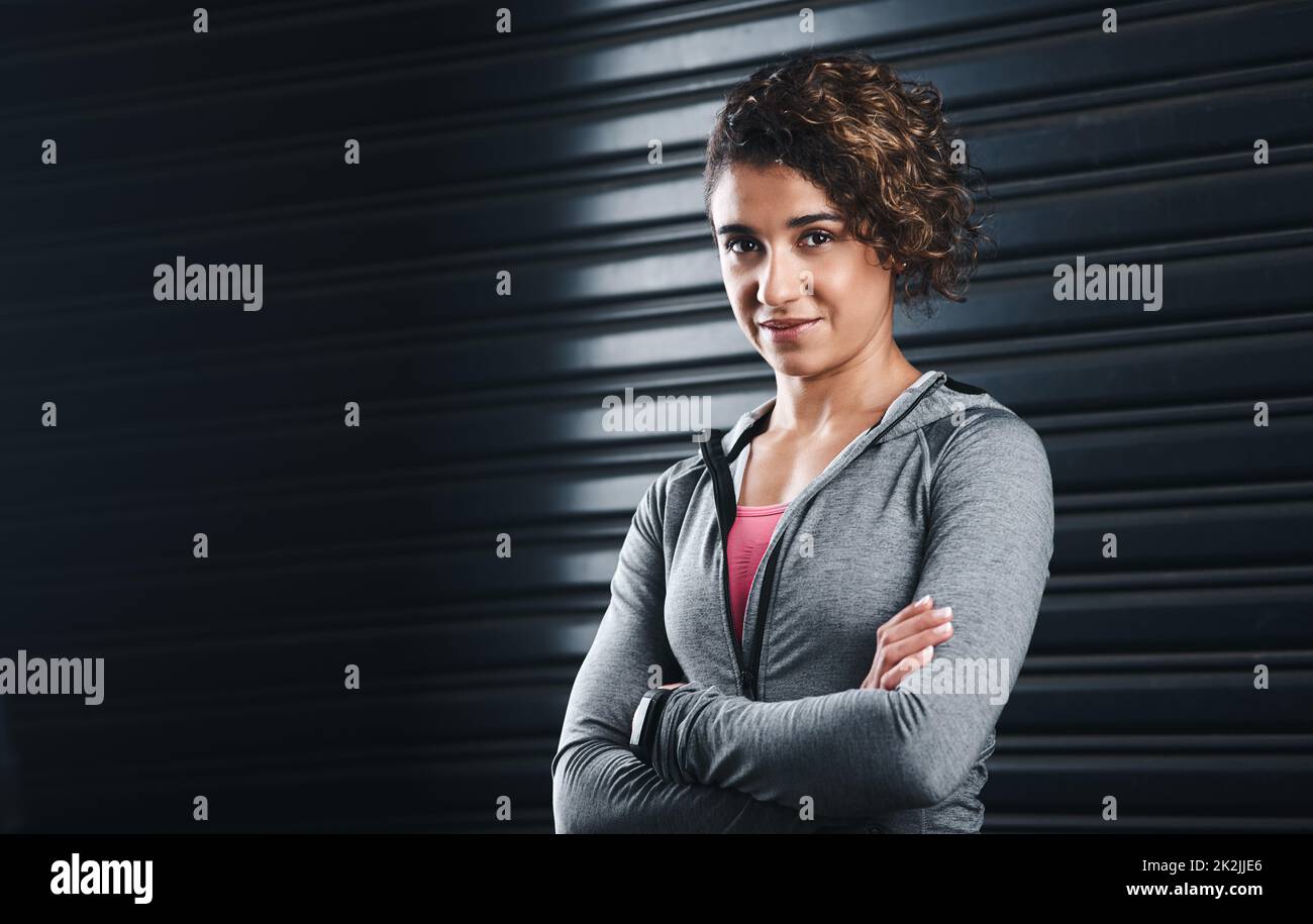 Focused on my healthy goals. Cropped portrait of an attractive young woman standing against a black background in her workout clothes before exercising. Stock Photo