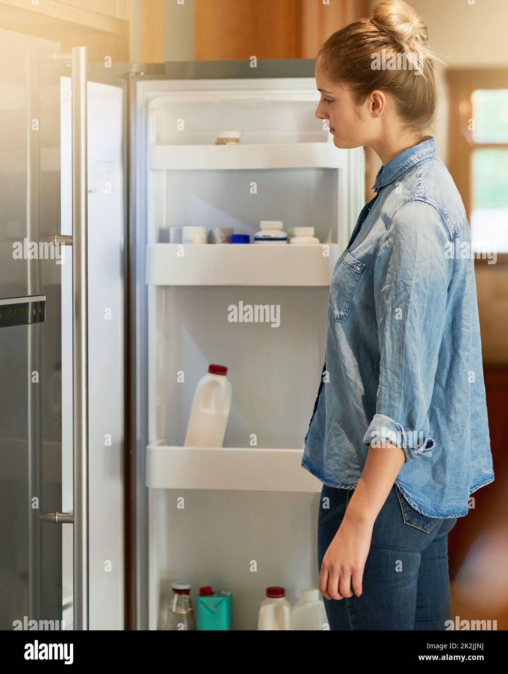 Young woman looking inside fridge hi res stock photography and