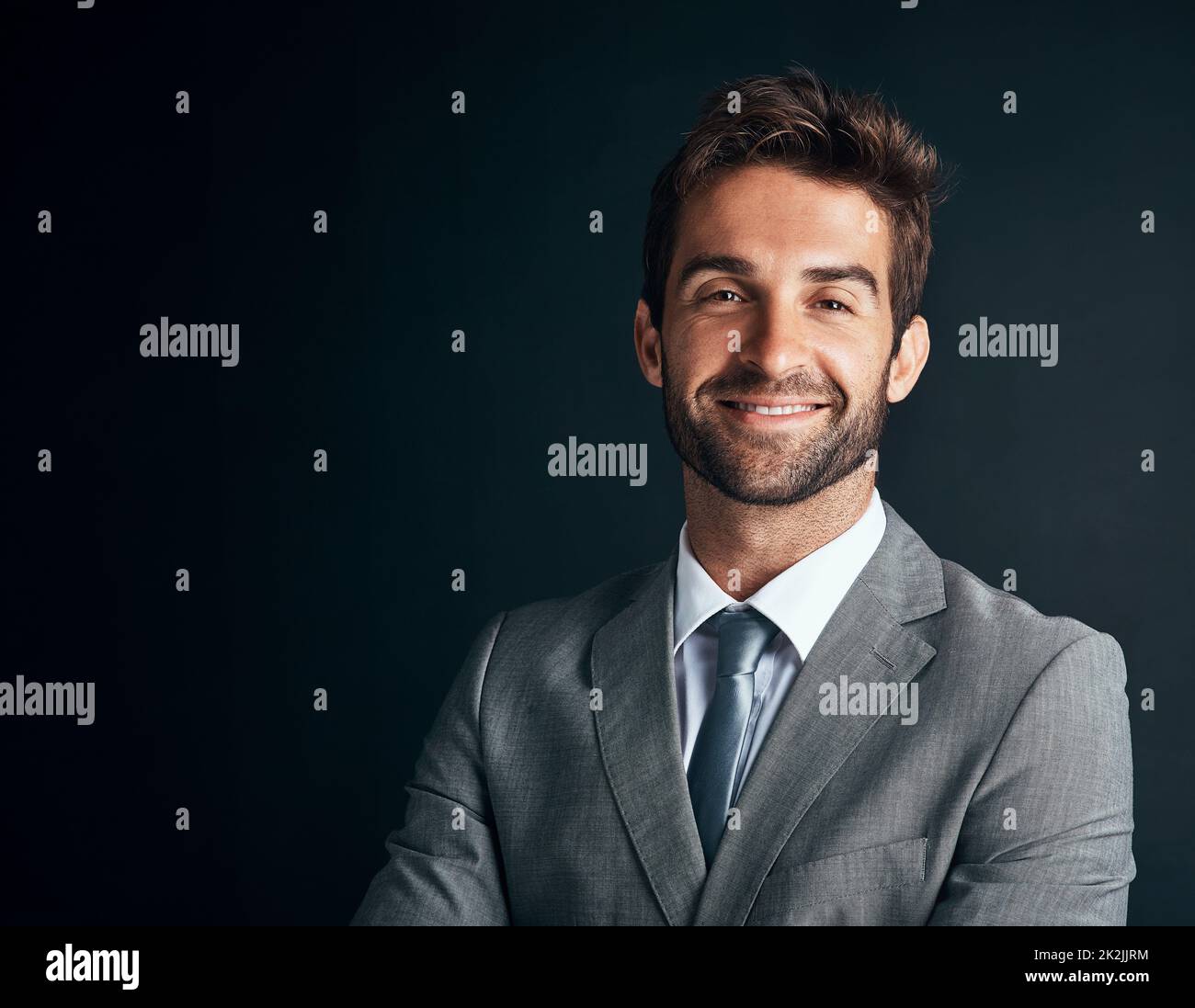 Im living proof of business success. Studio shot of a confident and stylishly dressed young businessman against a black background. Stock Photo