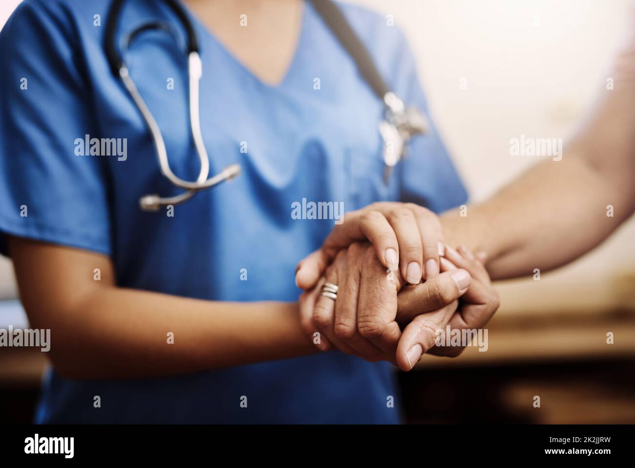You dont have to face your challenges alone. Cropped shot of an unrecognizable female nurse holding a senior womans hands in comfort. Stock Photo