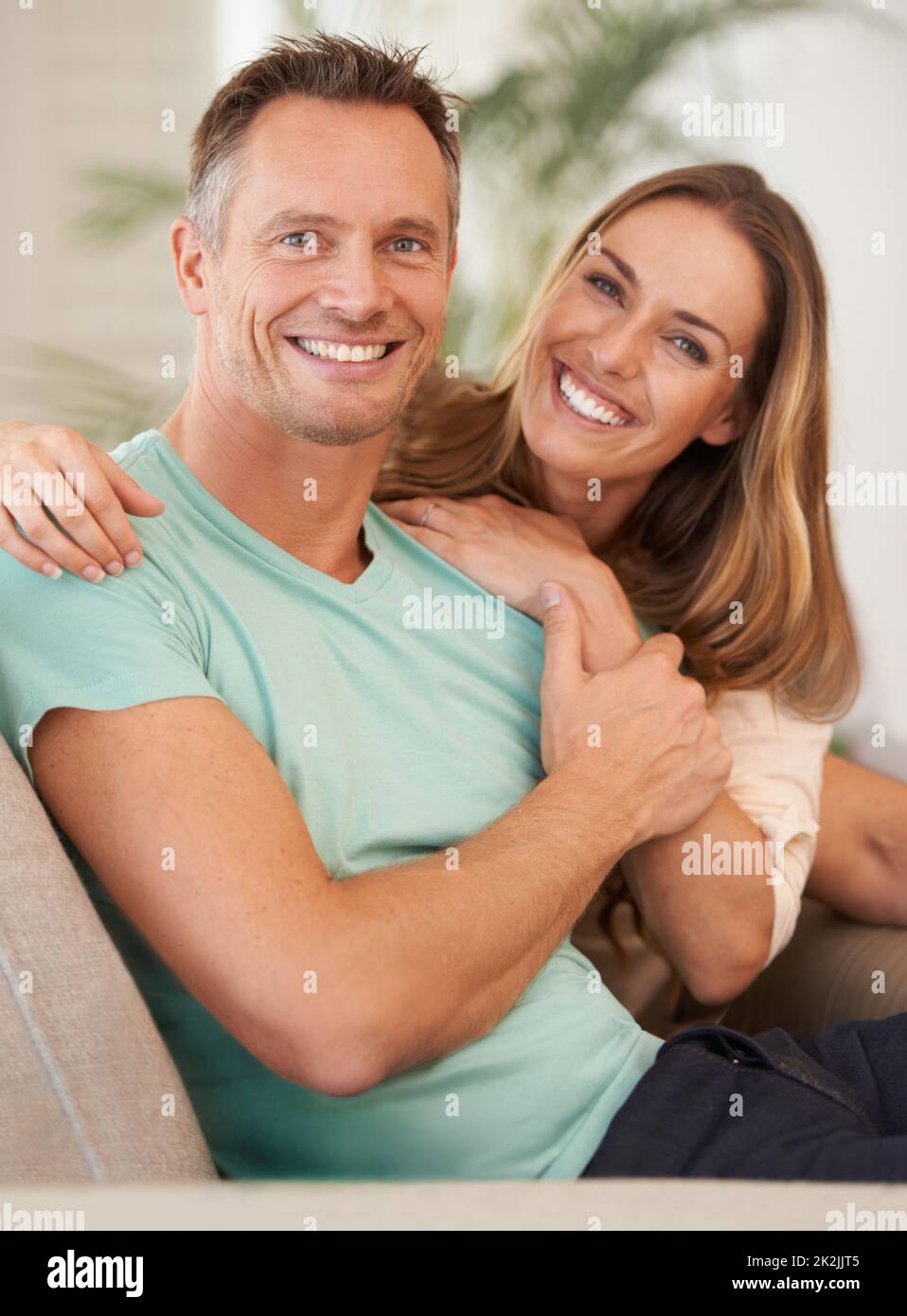 The picture perfect couple. Portrait of a happily married couple sitting on the sofa at home. Stock Photo
