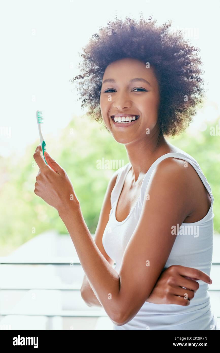 Fresh breath, now ready for the day. Cropped shot of an attractive young woman brushing her teeth in the bathroom at home. Stock Photo