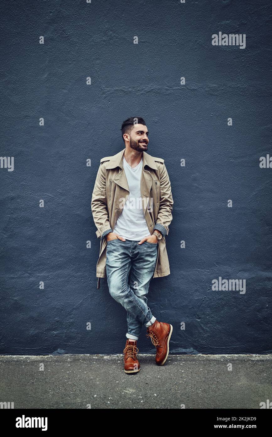 Style thats hot off the street. Shot of a fashionable young man wearing urban wear and posing against a gray wall. Stock Photo