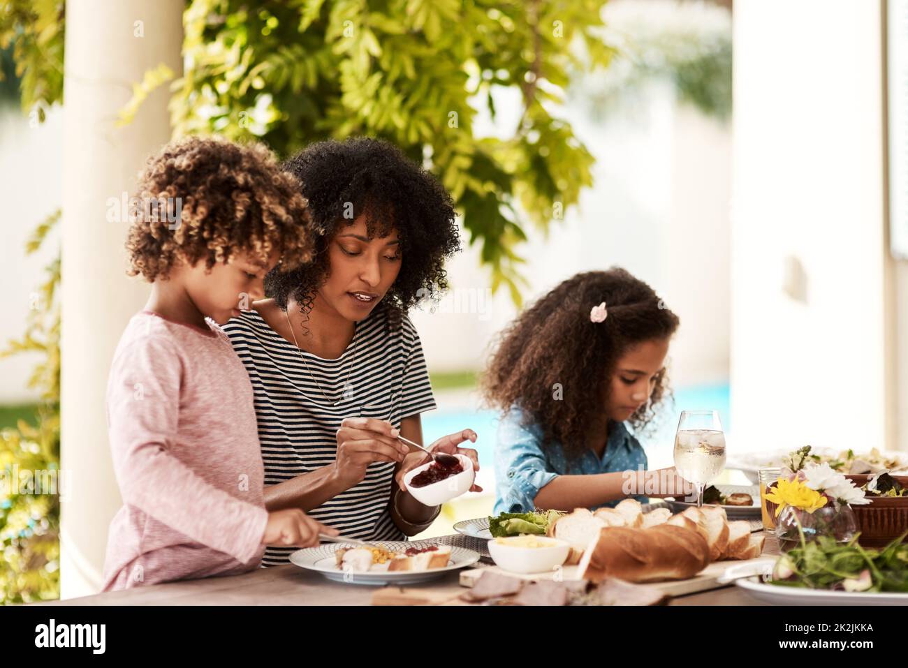 Lets eat kids. Cropped shot of a young woman enjoying a meal with her children at home. Stock Photo