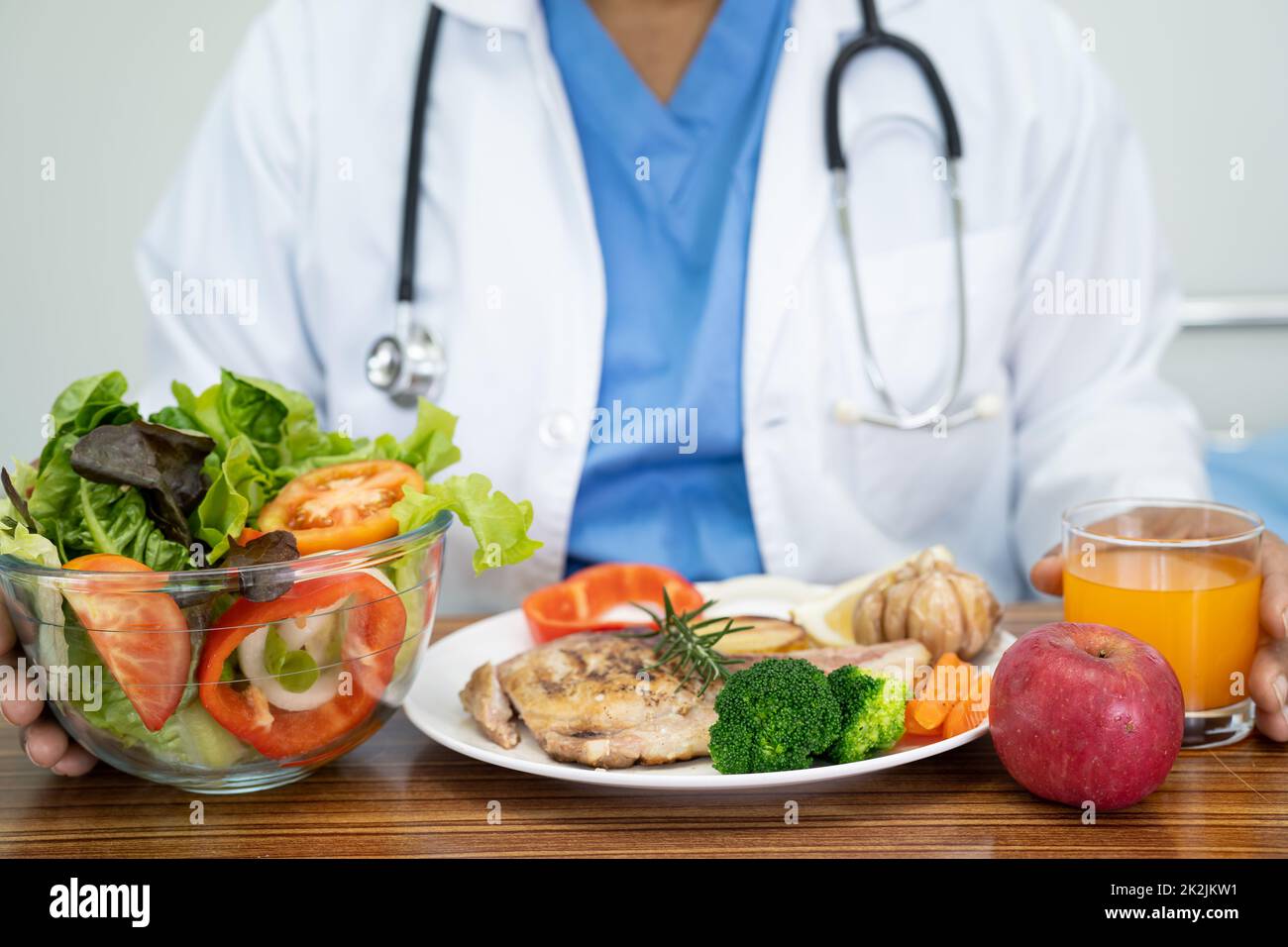 Nutritionist doctor with various healthy fresh vegetables for patient. Stock Photo