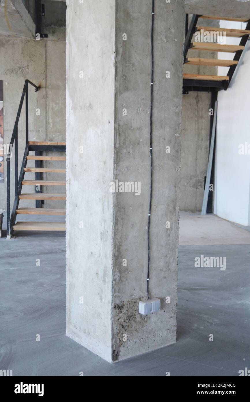House concrete column with wire and outlet plug. Stock Photo