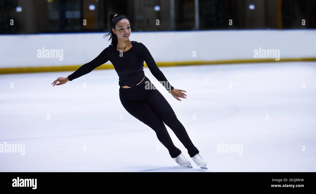 Balance is all a skate of mind. Shot of a young woman figure skating at a sports arena. Stock Photo