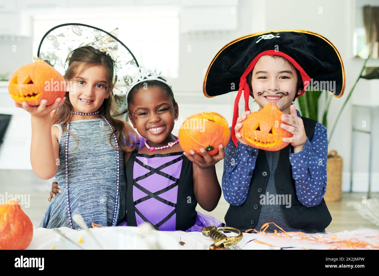 Some pumpkin party fun. Shot of a group of little children showing their carved pumpkins at a party. Stock Photo