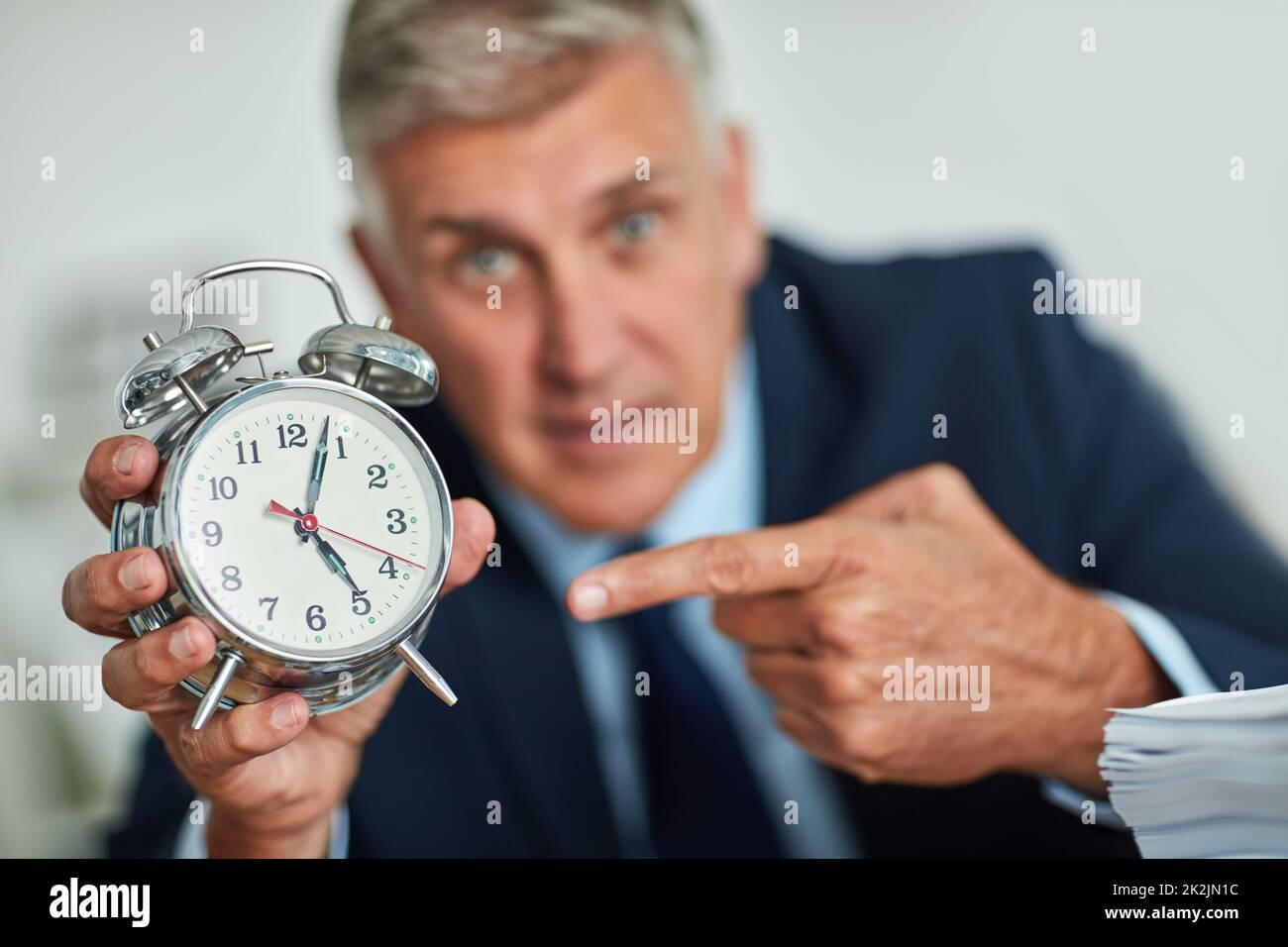 The clocks ticking. Portrait of a mature businessman gesturing toward a