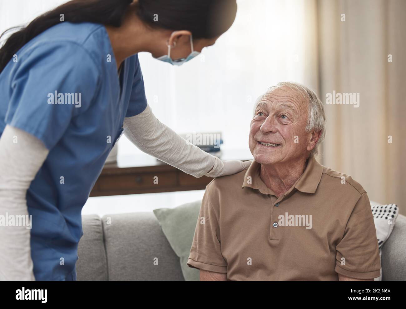 Im here for anything you need. Shot of a young female nurse having a checkup with an elderly patient at home. Stock Photo