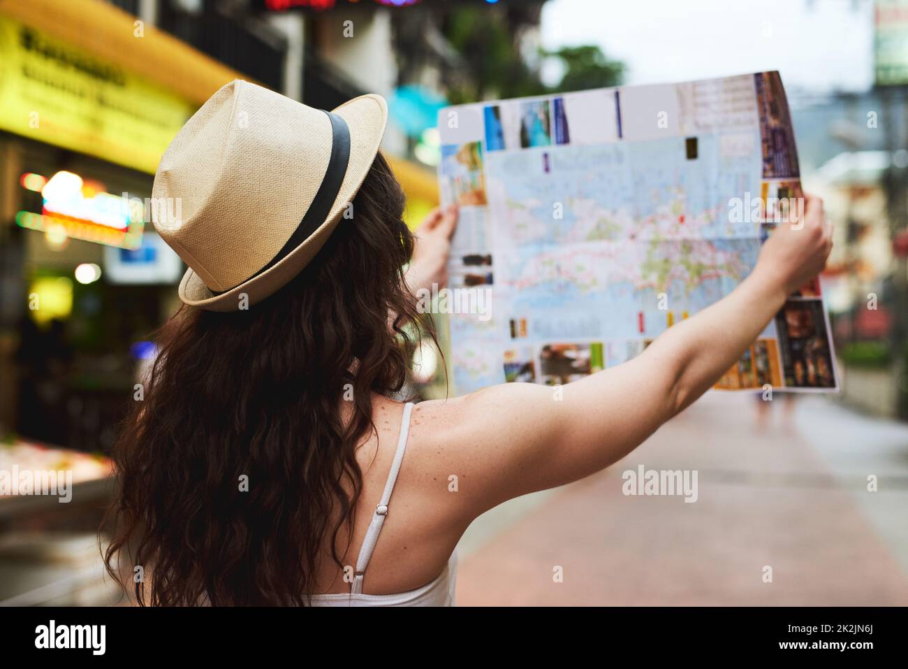 On a mission to see as many attractions as possible. Cropped shot of a young woman using a map while travelling in a foreign city. Stock Photo