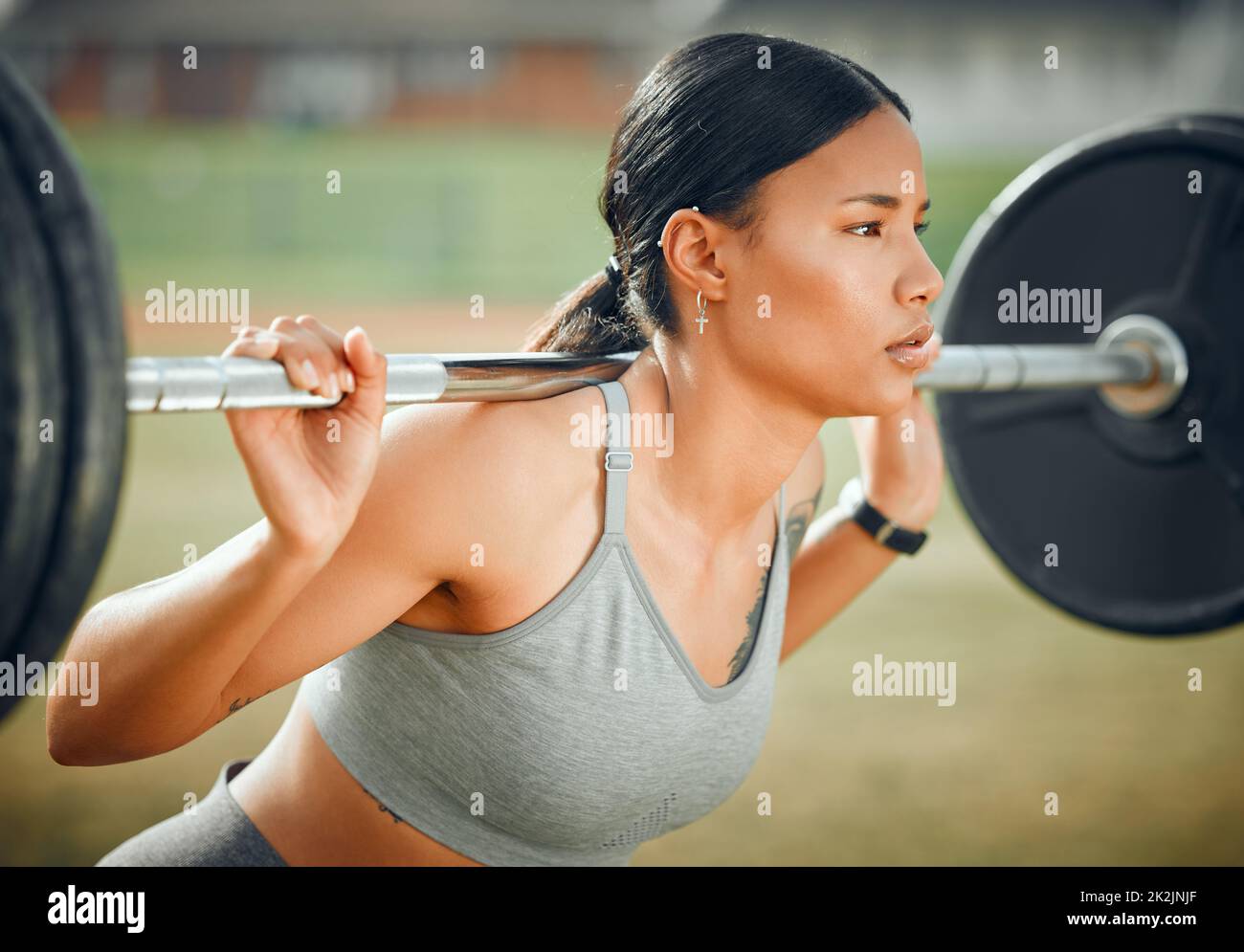 Lifting her spirits. Cropped shot of an attractive young female athlete exercising with weights outdoors. Stock Photo