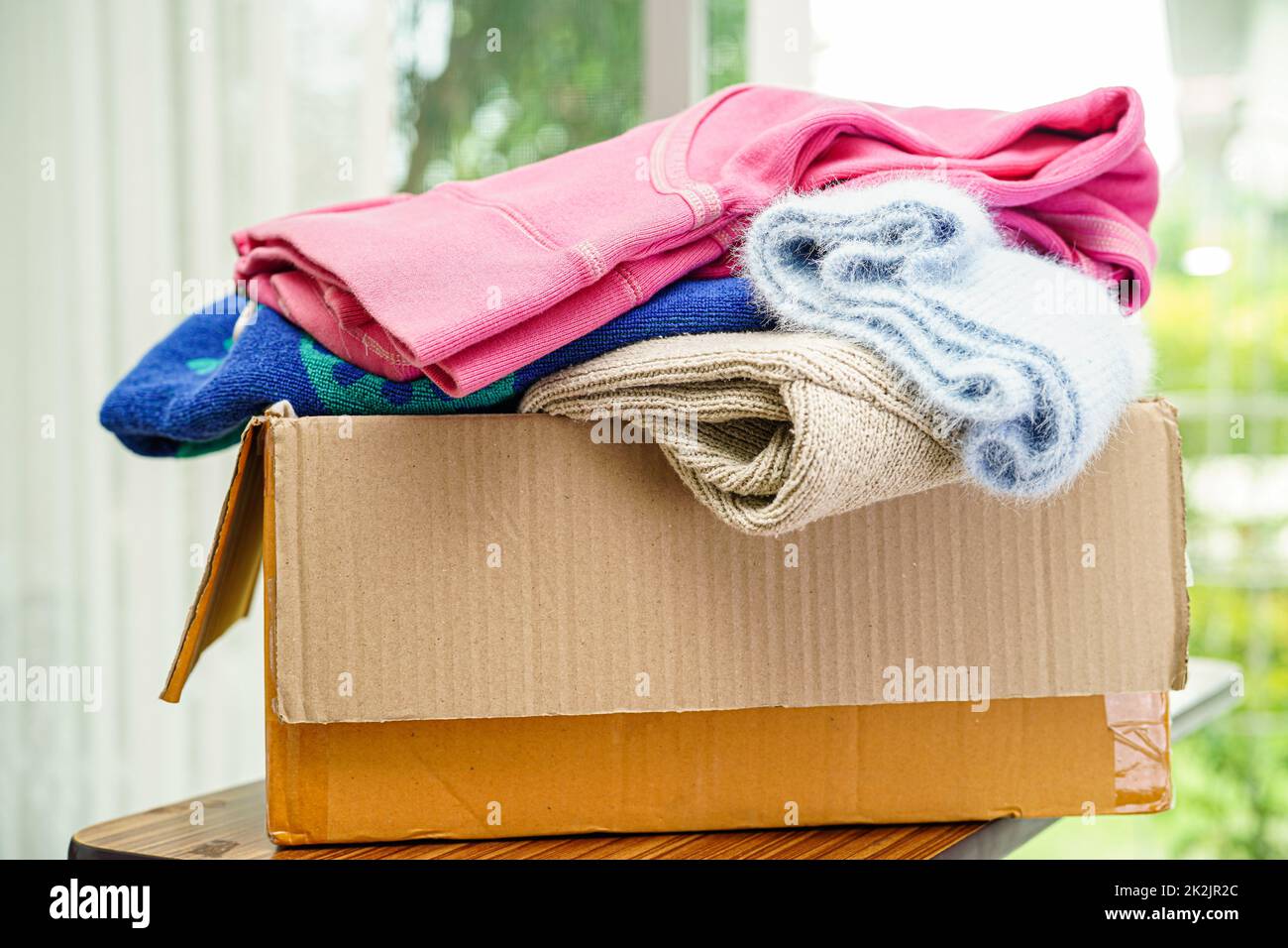 Clothes donations in cardboard box for volunteer Stock Photo Alamy