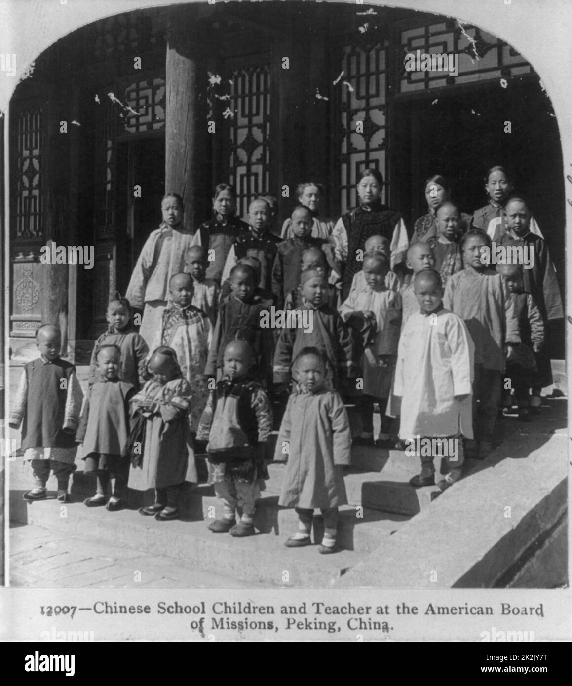 Chinese school children and teacher [standing on steps] at the American Board of Missions, Peking, China Published: c1900. photographic print or stereo card /stereograph. Stock Photo