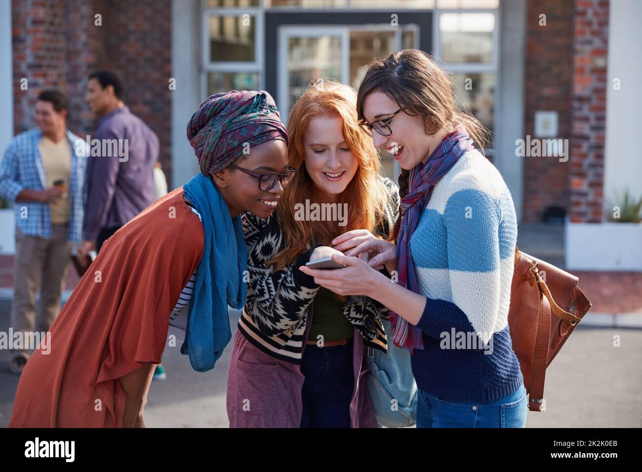 Let me show you the text he sent.... Cropped shot of a group of university students hanging out between class. Stock Photo