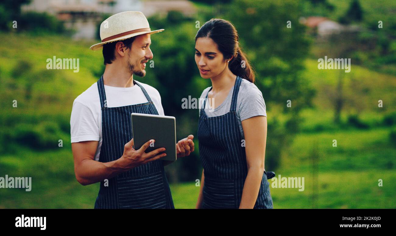 Transforming the farming experience with smart technology. Shot of a young couple using a digital tablet together while working in a garden. Stock Photo