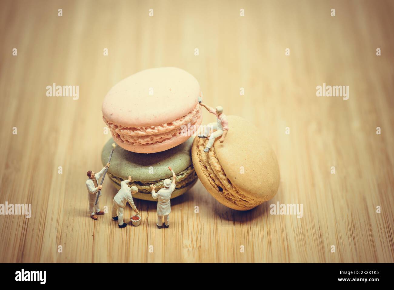 Group of miniature painters coloring macaroon. Color tone tuned. Stock Photo
