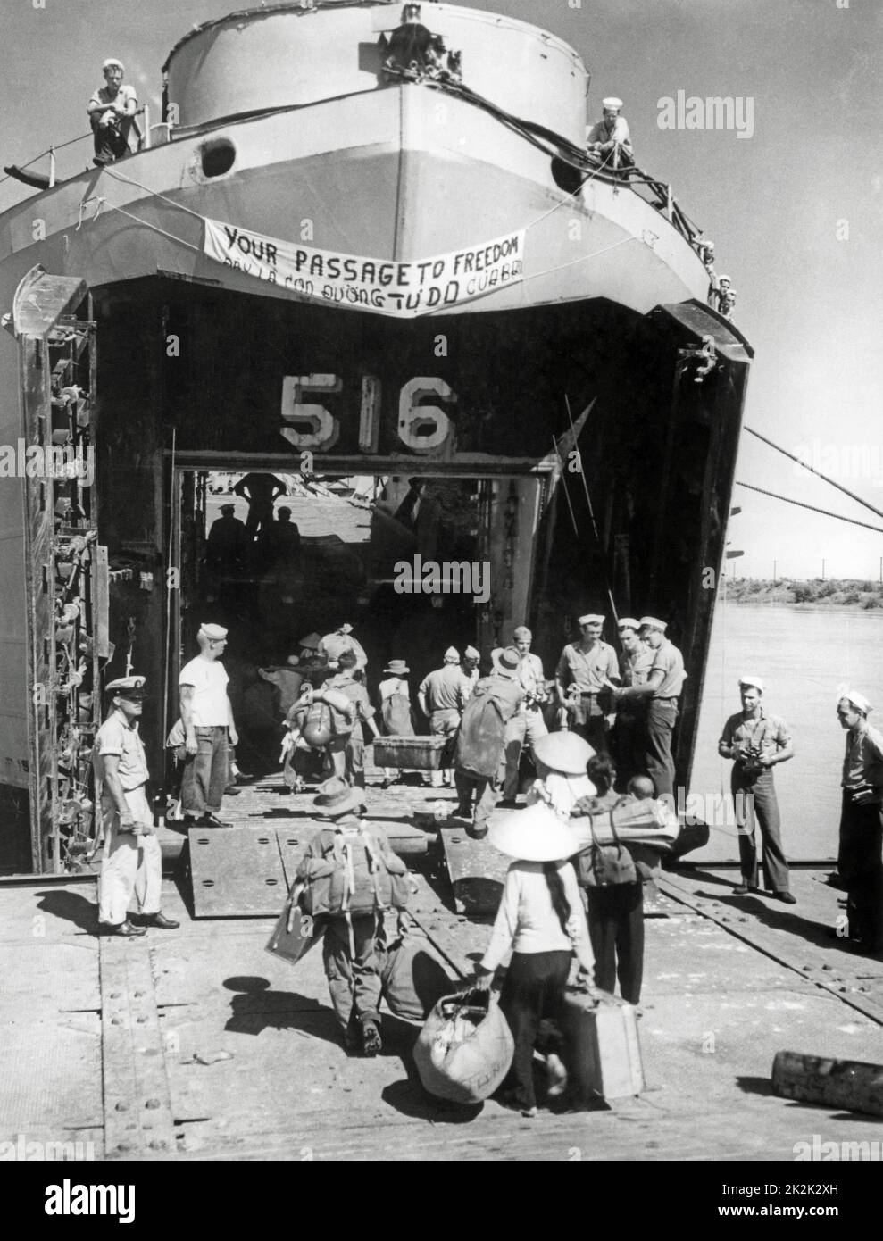 At the end of the Indochina War, hundreds of Vietnamese refugees embarking a United States Navy boat to go to the Republic of Vietnam. This operation will be called 'Operation Passage to Freedom'. October 1954 Stock Photo