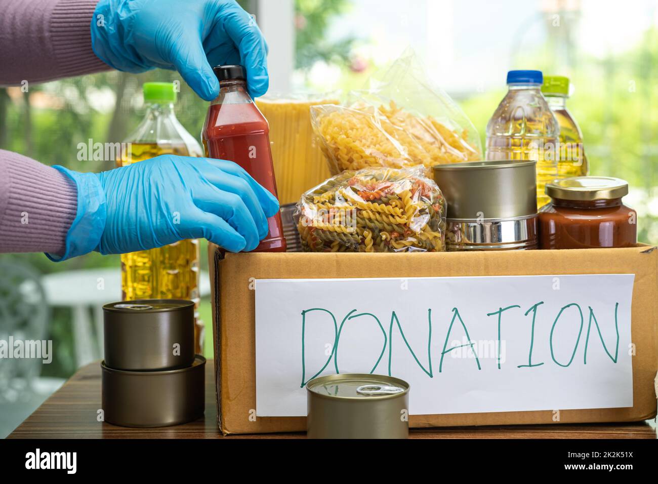 Foodstuff for donation, storage and delivery. Various food, pasta, cooking oil and canned food in cardboard box. Stock Photo