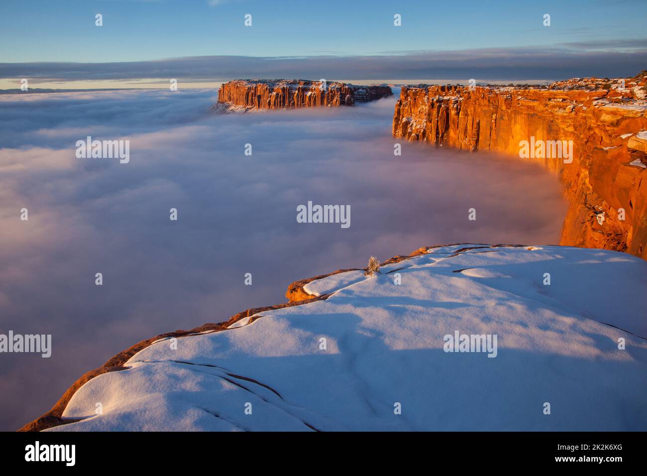 First light at sunrise on the Wingate cliffs of Junction Butte & Grandview Point with a sea of clouds below. Canyonlands NP, Utah.  A winter temperatu Stock Photo