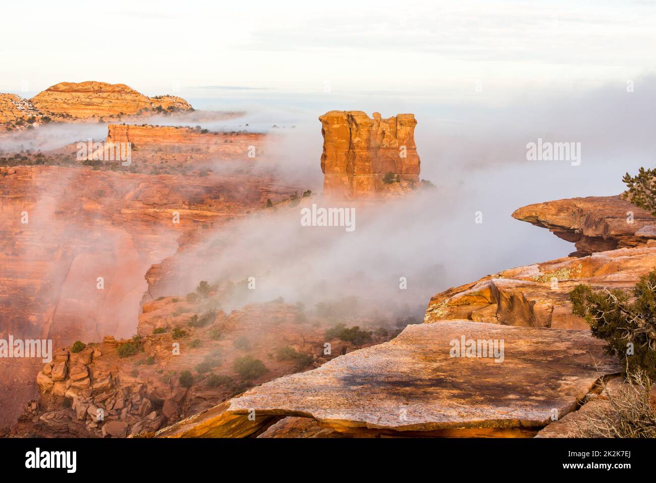 Low clouds flow off the mesa top into the Green River Basin during a