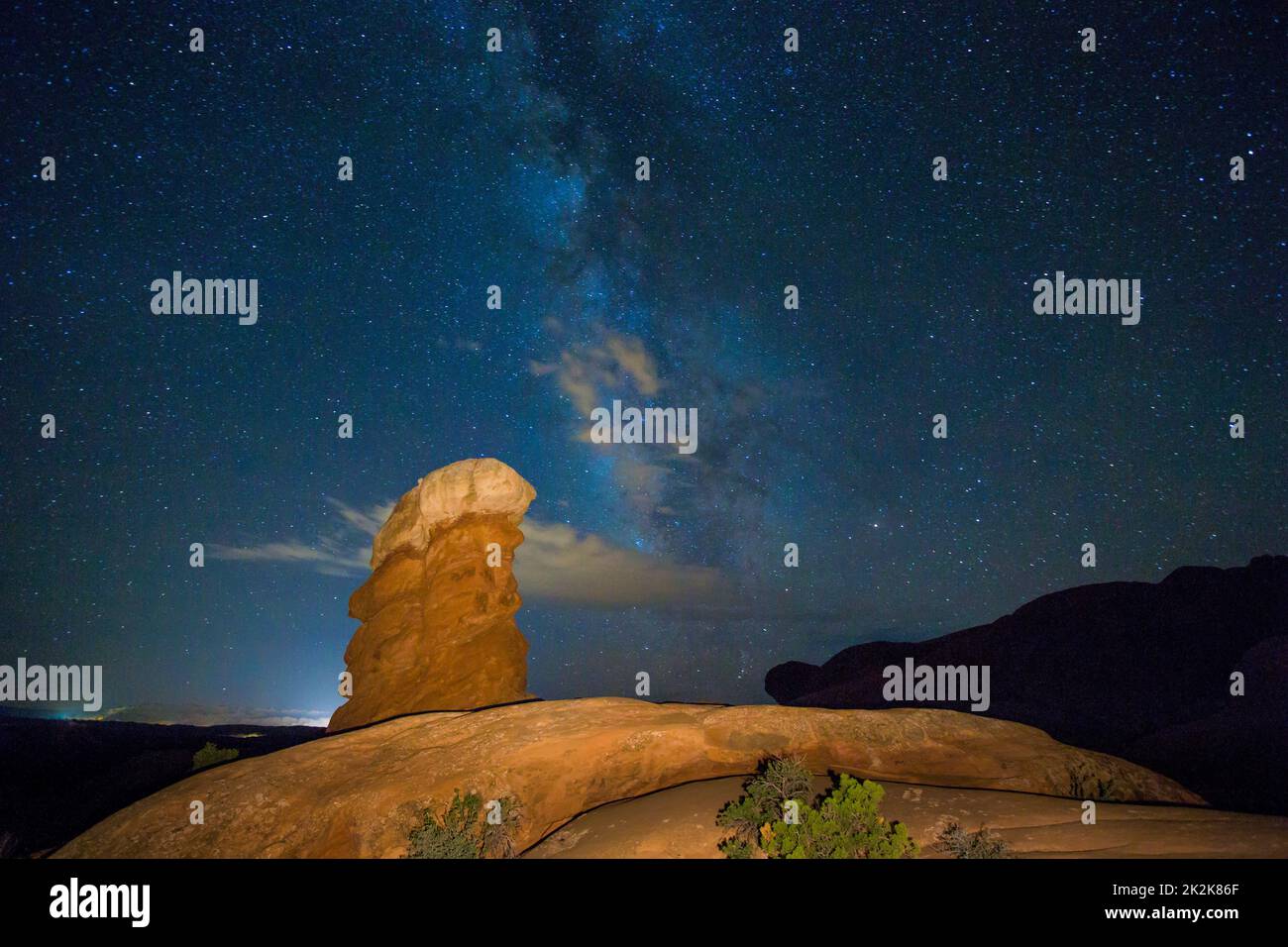Stars and clouds over an Entrada sandstone rock spire at night in ...