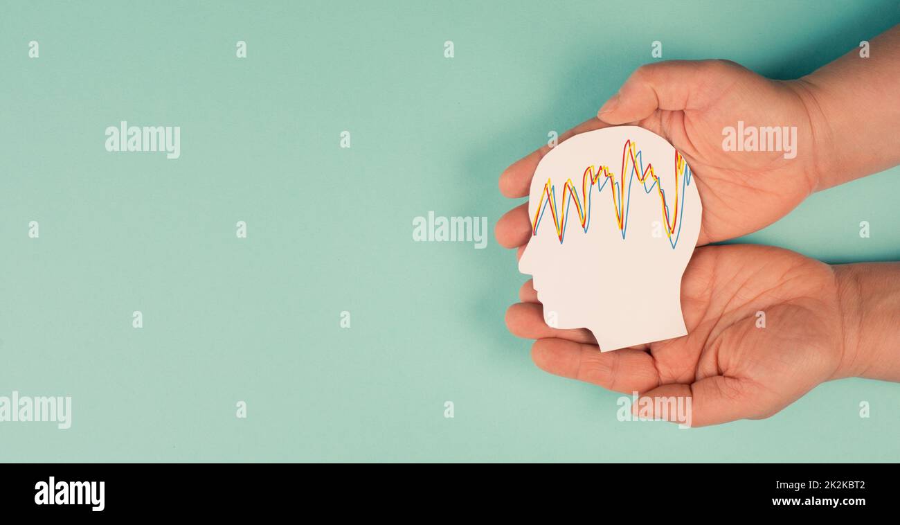 Holding a head in the hands, mental health concept, alzheimer and epilepsy disorder, brain waves, paper cut out Stock Photo