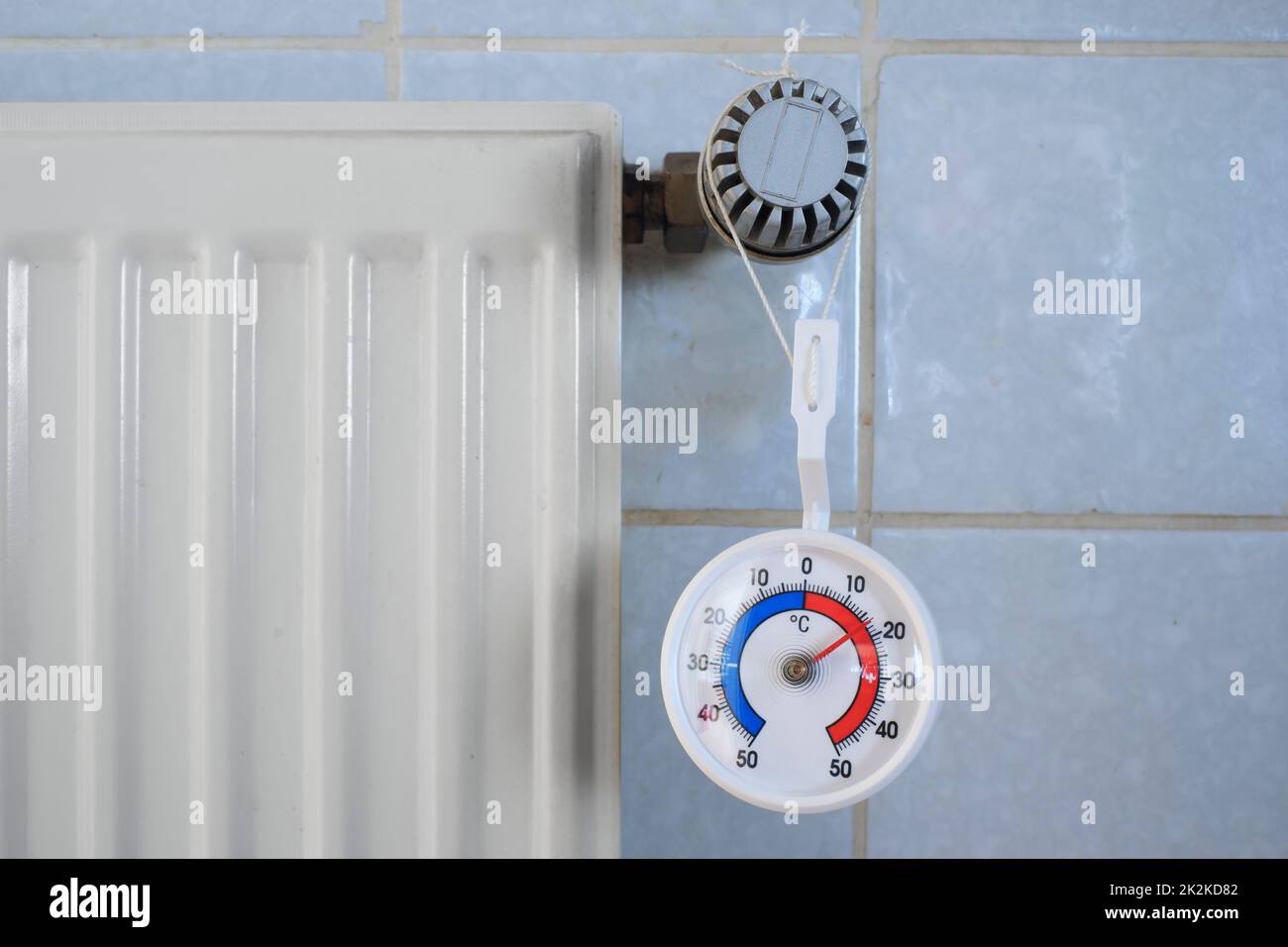 Radiator,valve and thermometer showing low temperature, shortage of heating gas and oil due to the embargo of russian oil and gas in europe Stock Photo