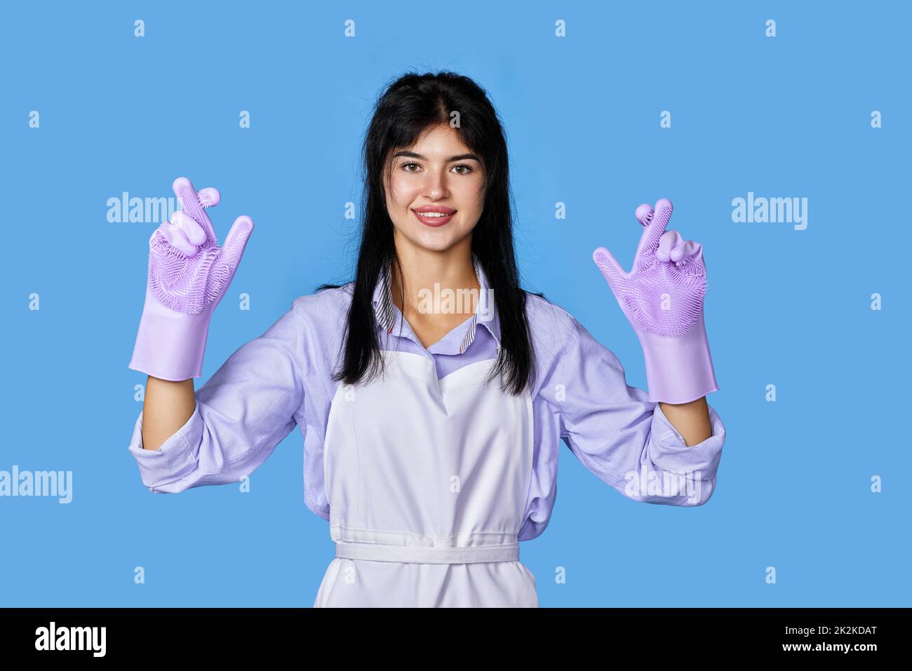 woman in rubber gloves with finger crossed gesture Stock Photo - Alamy