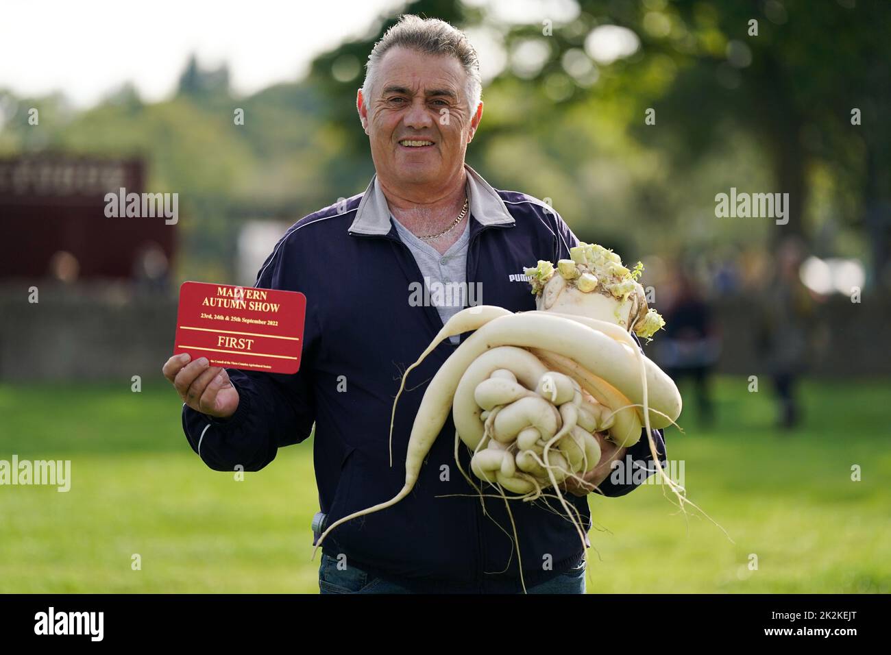Paul Rochester holds his winning mooli radish entry, weighing 12.5kg, during the Canna UK Giant Vegetables Championship at the Malvern Autumn Show, Three Counties Showground, Malvern, Worcestershire. Picture date: Friday September 23, 2022. Stock Photo