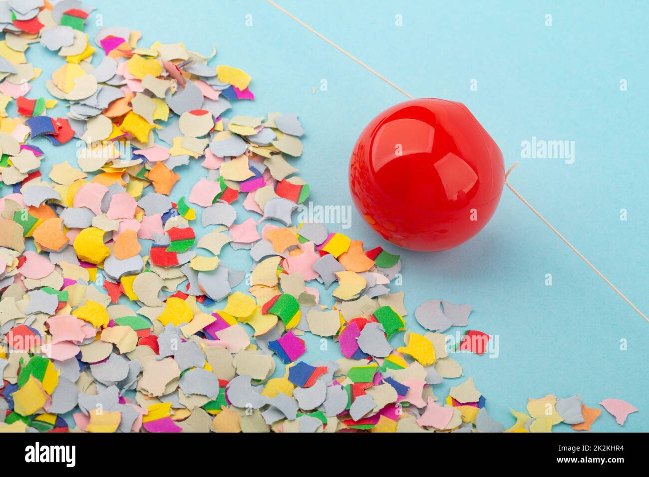 Red Nose with confetti over light blue background. Stock Photo
