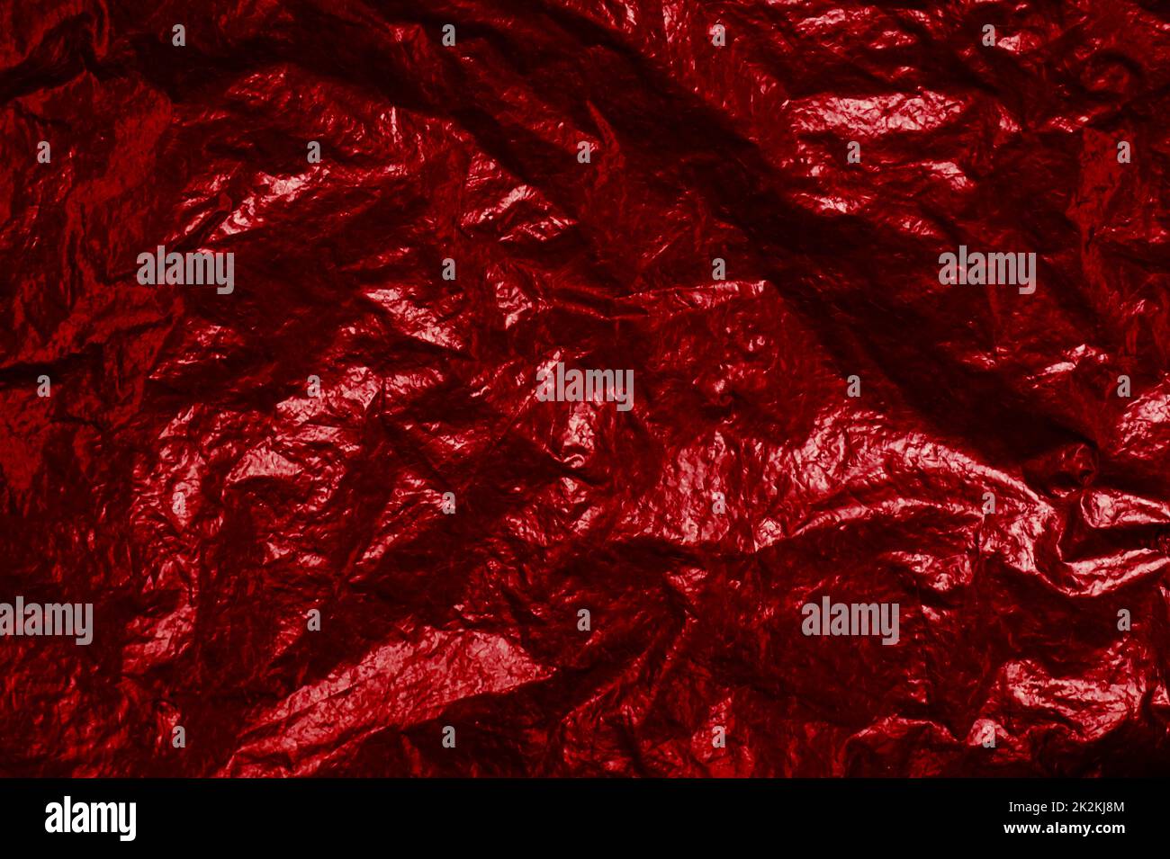 Crumpled red foil background texture with light reflection Stock Photo