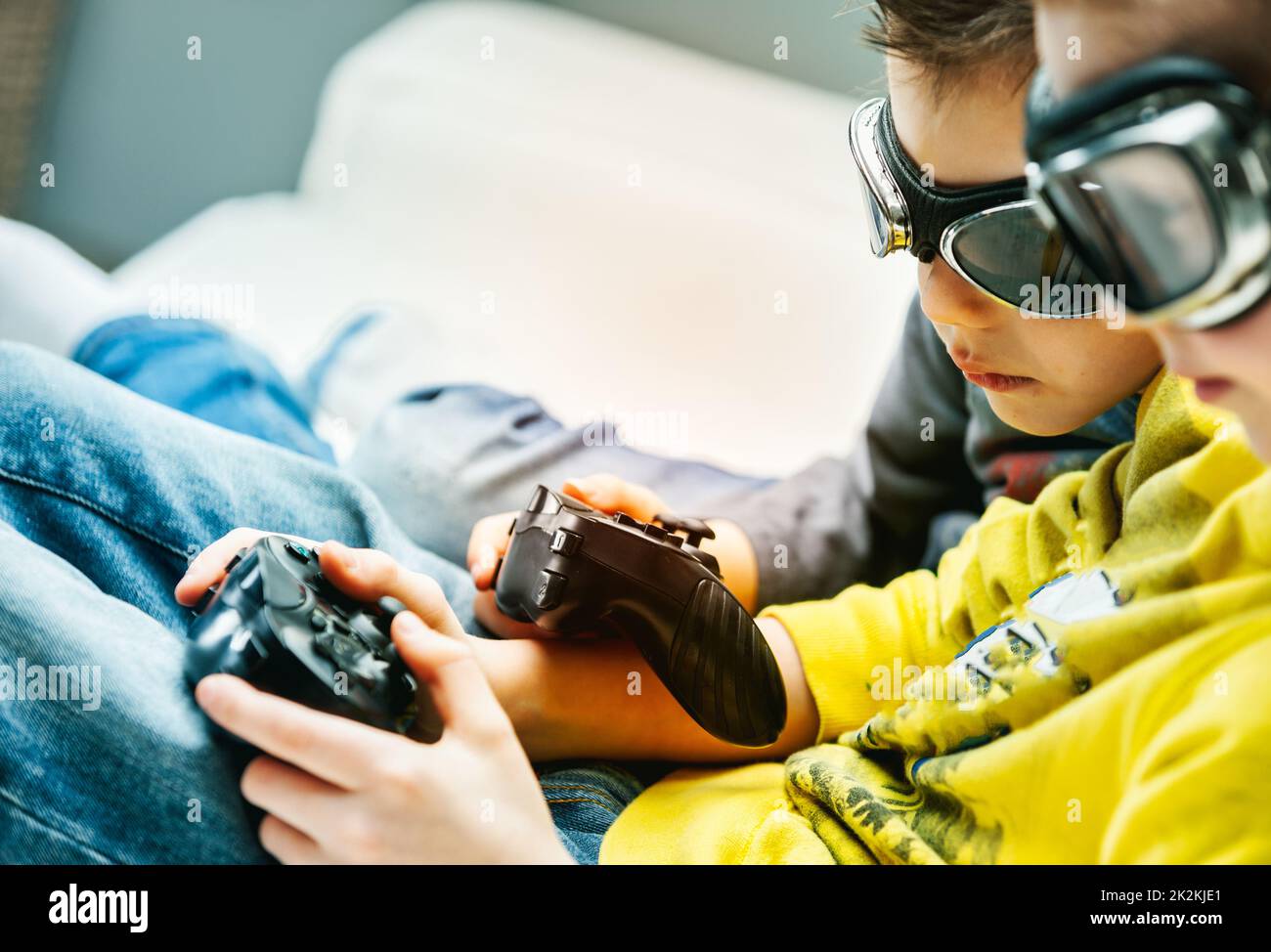 Young brothers wearing goggles huddling together playing games Stock Photo