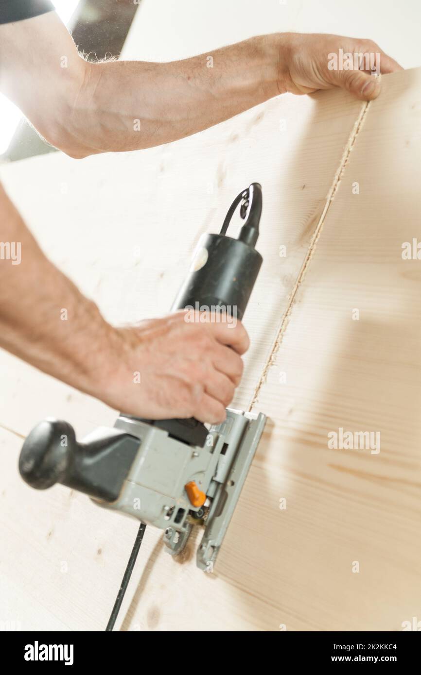 amrs of a woodworker cutting a plank Stock Photo