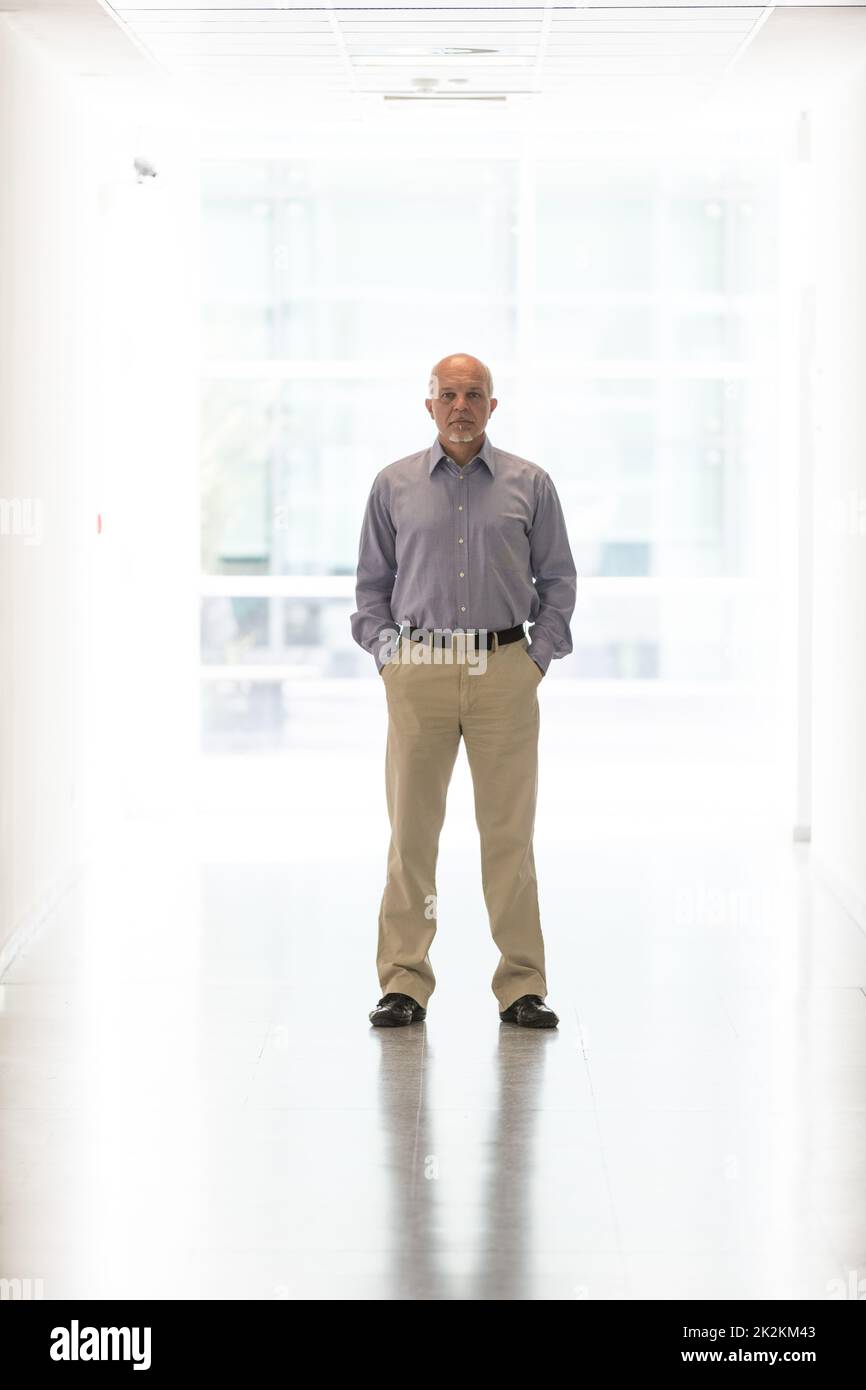 full-length portrait of a man standing in the hallway inside a modern new building Stock Photo