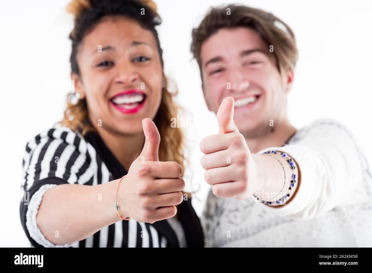 Two young happy people giving thumbs up Stock Photo
