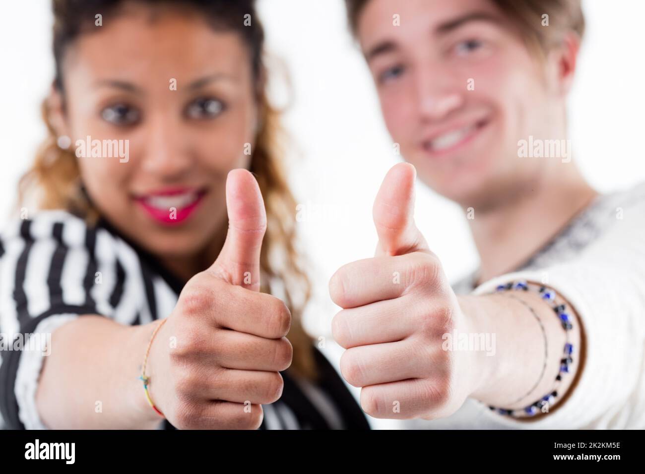 Two young people giving thumbs up in close up Stock Photo