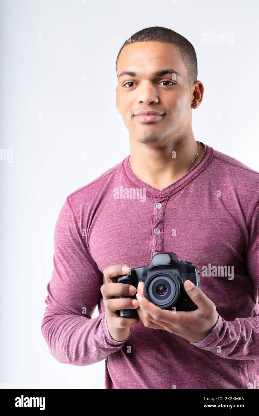 Young Black photographer standing holding his camera Stock Photo