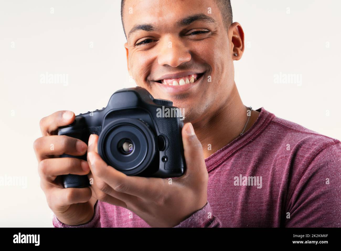Smiling friendly male photographer holding his camera Stock Photo