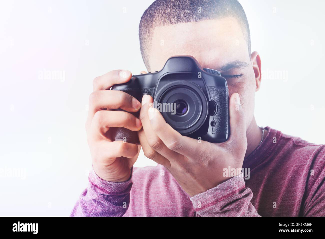 High key portrait of a Black male photographer with camera Stock Photo