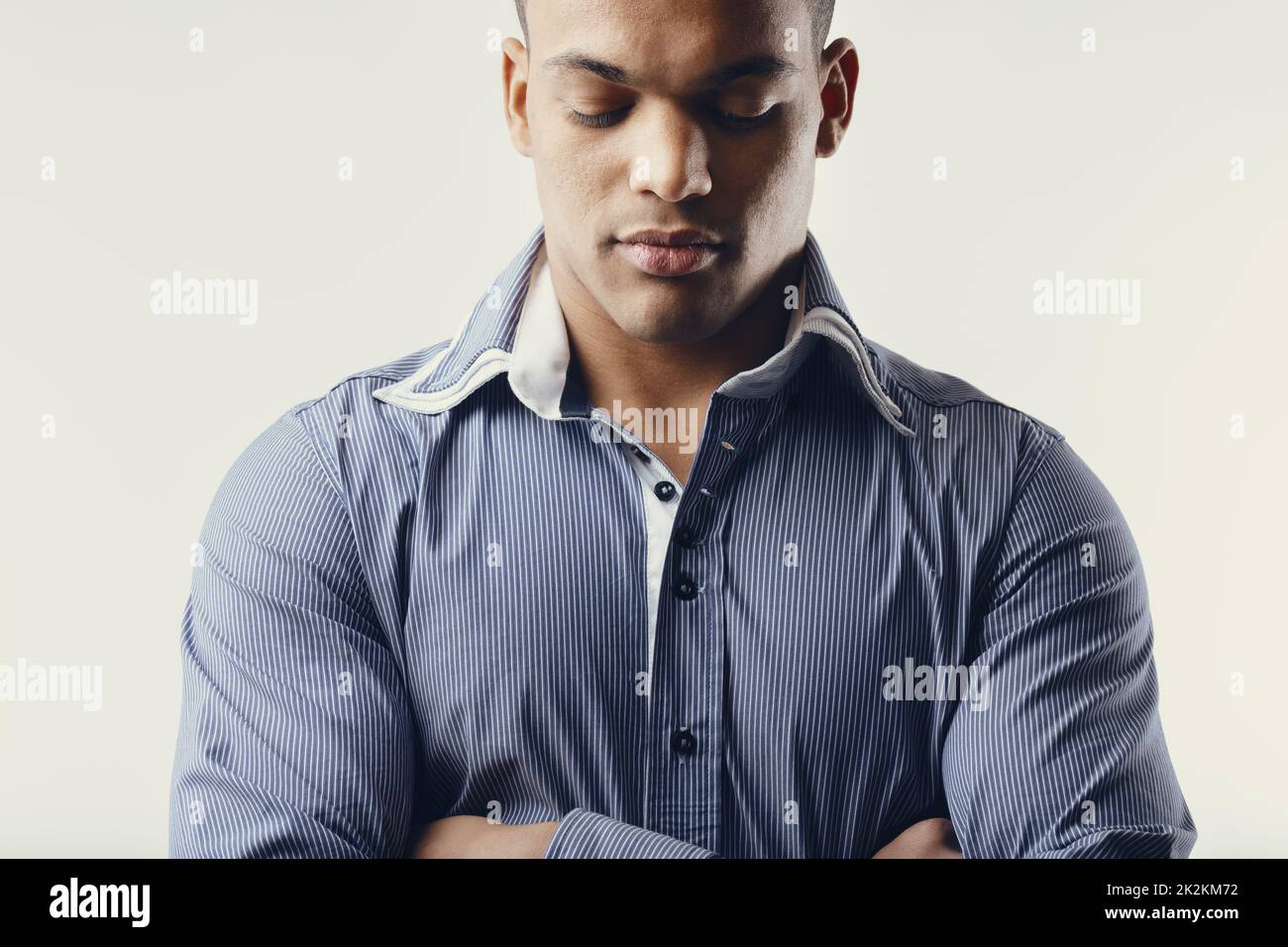 Young Black man standing with folded arms and closed eyes Stock Photo