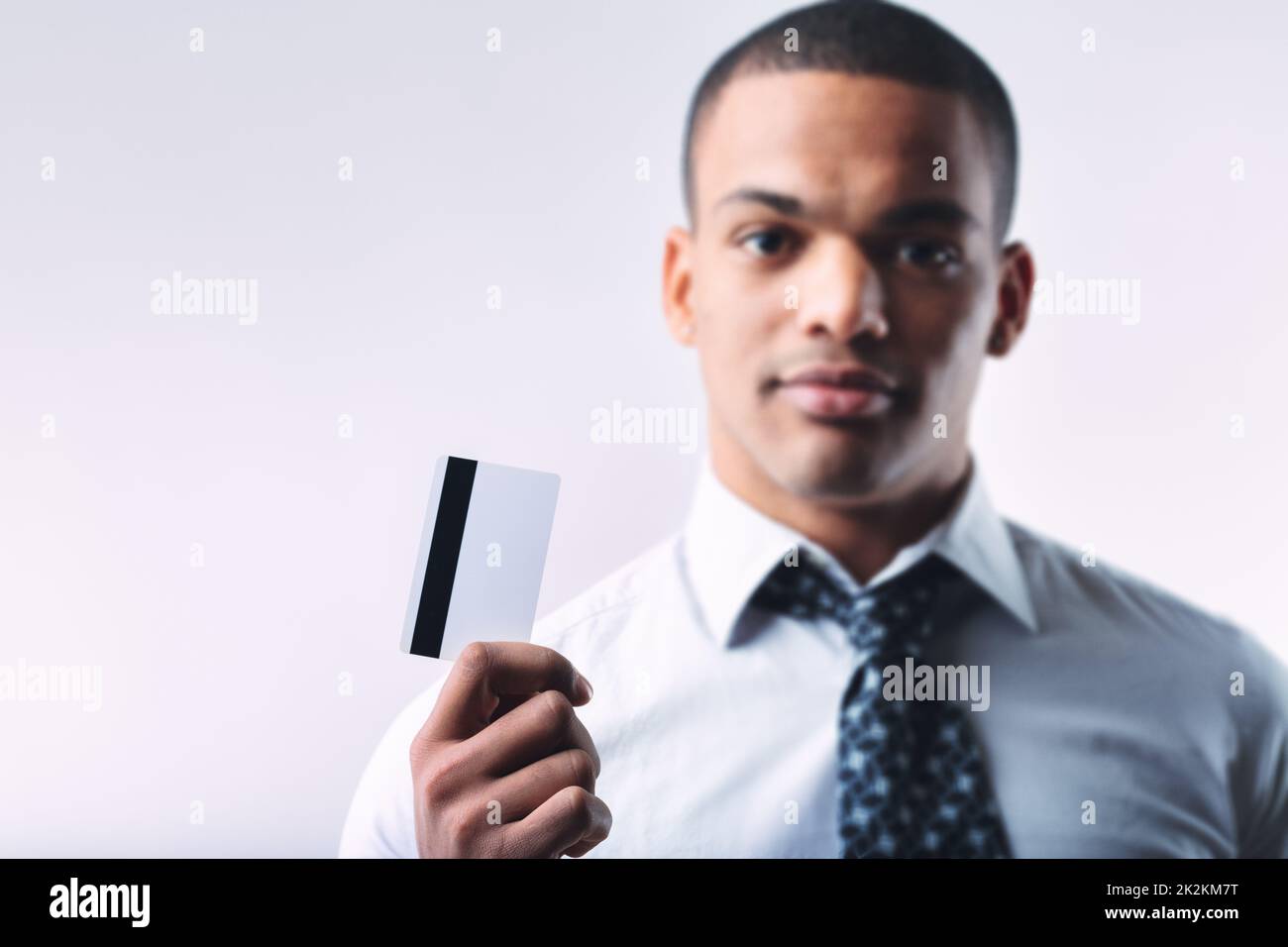 Young businessman holding up a generic bank card Stock Photo
