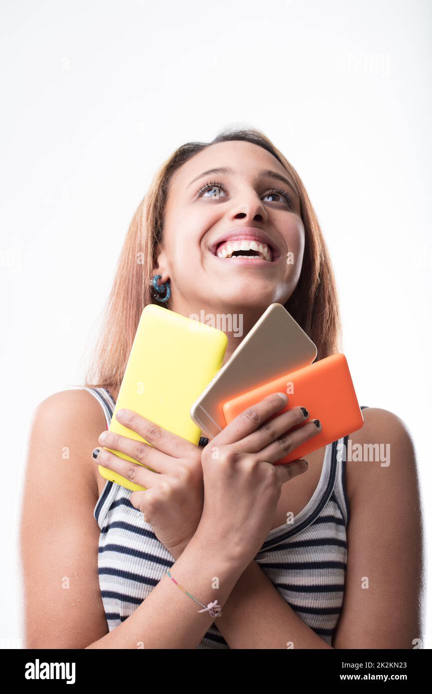 Happy young woman clutching an array of mobiles Stock Photo